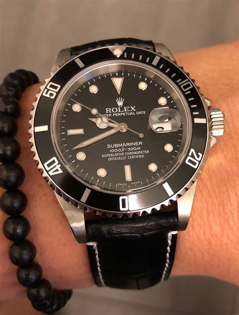 rolex with black leather band.